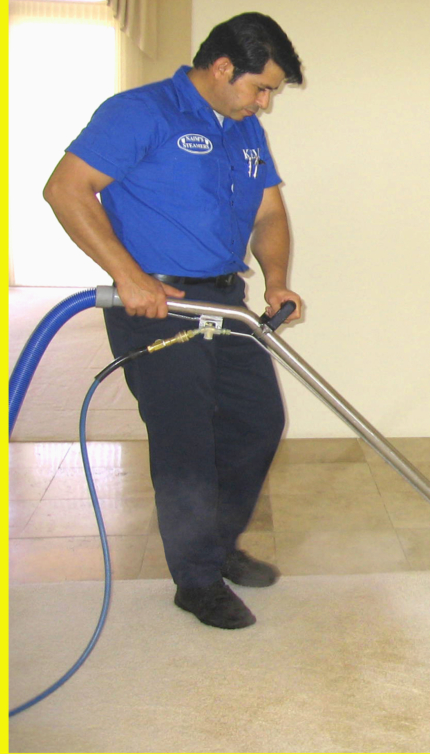 Naims Steamers technician steam-cleaning a carpet with a wand